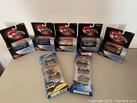 Overview of six individual boxed Hot Wheels cars and two multi-packs set against a plain background.