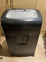 Front view of the black and silver shredder showing the main body and wheels.