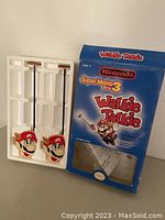 Pair of Mario face shaped walkie talkies with antennas next to original blue box and white plastic insert