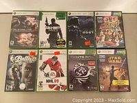 Photo of Xbox 360 games lot with 8 game cases visible, showing cover art for the titles.