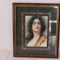 Framed portrait painting of a woman with dark hair and a gold-toned garment, featuring signature A.M. Turner in pencil.