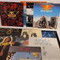 Photo showing several Aerosmith albums including Permanent Vacation, Rock in a Hard Place, and others alongside AC/DC albums.