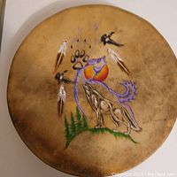 Front side showing hand-painted Native American-inspired artwork of a wolf howling at a stylized sun with feathers, trees, and paw print on drum surface.