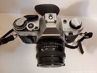 Top front view of Canon AE-1 with 50mm lens, showing eye shield and top controls.