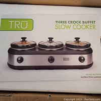 Photo showing the front of the box with image of the three crock buffet slow cooker and brand name Tru.