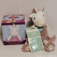 Photo showing Dazzle the Unicorn plush with original box and sealed aloe water & cucumber scent pack.