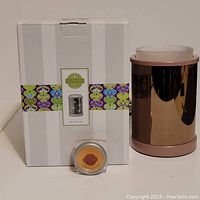 Scentsy Star Dance wax warmer with its original box and a small sample wax melt in caramel vanilla scent shown in front.