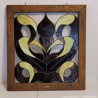 Front view of the stained glass window showcasing abstract floral design and wood frame.