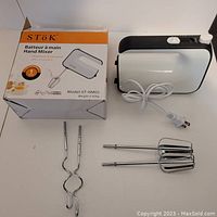 Photo of the hand mixer with original box, showing the mixer, dough hooks, and beaters laid out on table.