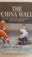 Front cover of the hardcover book showing Johnny Bower in hockey gear on ice and the title 'The China Wall: The Timeless Legend of Johnny Bower'.