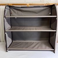 Front view of fabric three shelf storage unit showing the three shelves and overall structure.