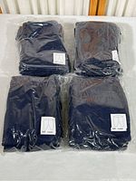 Four sealed packages containing navy blue play pants size 4 years, each package labeled and showing quantity of pants per package.