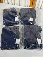 Four packages of navy blue child’s pants, each package sealed in plastic containing 5 pants, total 20 pants.