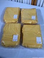 Four sealed packages containing yellow child’s play pants, labeled size 4 years, color yellow, 5 pants per package, total 20 pants.