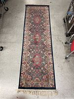 Full length overhead photo of the narrow woven rug runner showing color pattern and condition.