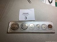 Full view of the six Canadian 1969 coins in sealed protective plastic holder, showing all coins and MaxSold tag.