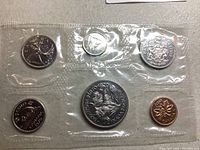 Close-up photo of one plastic sealed package containing six coins from 1970 including various national symbols and figures.