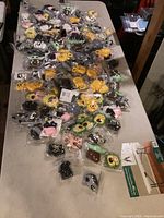 Multiple new AirPod cases in various cartoon and character themes displayed on a table, all individually packaged unopened.