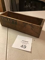 Full view of the rectangular wooden box branded with Kraft logos and text, showing the interior and exterior wear.