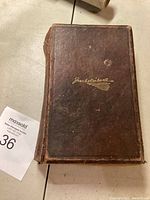 Brown hardcover book with visible wear on the cover and spine, gold embossed text on spine and front.