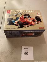 Boxed 1/25 scale Domino's Pizza March 86C model kit showing front with prominent Domino's branding and race car image.
