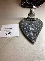 Soapstone incense dish shaped like a leaf with a Buddha figure sitting on top, showing top and angle views.