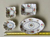 Photo from above showing all four serving dishes - two rectangular (one larger, one smaller), one oval, and one small fluted bowl, all with Royal Albert Petit Point floral design.