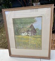 Framed pastel painting showing a rural barn with yellow flowers and trees in background.