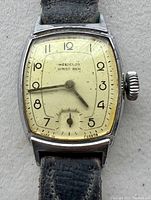 Front view of the vintage Westclox Wrist Ben wristwatch showing the cream dial with black Arabic numerals and small seconds subdial as well as the metal case and leather strap.