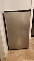 Front view of Frigidaire mini fridge showing stainless steel door with black sides and top.
