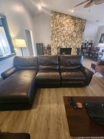 Frontal view of dark brown leather sectional with chaise and recliner in living room