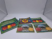 Set of eight vintage apple crate labels laid out on white background showing multiple designs and colors