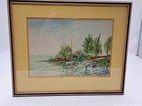 Full view of framed watercolour artwork showing lakeside boats and trees under a cloudy blue sky.