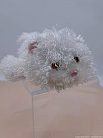 Front side view of a white fuzzy cat hand puppet with visible facial features including pink nose and multi-colored eyes.