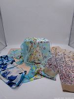 Four scarves laid out with variety of colors and floral/abstract patterns