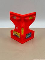 Front view of the orange Strike post level showing three bubble vials and label.