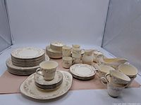 Full set of china pieces including plates, cups, saucers, creamers, and gravy boats arranged on a flat surface.