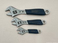 Photo showing three Mastercraft crescent wrenches with blue rubber handles, arranged large to small.