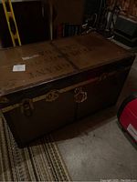 Metal army trunk showing top with stenciled markings including the word "Grant" and metal corner reinforcements.