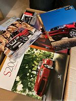 Photo showing multiple auto brochures including Honda, Toyota and others in two boxes.