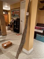 Full view of the driftwood piece leaning against a wall showing its length and natural shape.