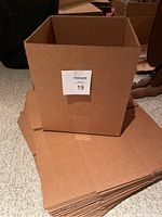 Stack of flat-packed and one assembled cardboard box with size approximately 10x10x6.6 inches.
