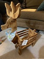 Full view of handmade wooden reindeer holder showing shape, finish, and fabric bow around neck.