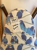Close-up photo of the ironing board's blue bird patterned fabric cover and metal legs.