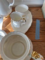 Porcelain pieces including creamer and oval tray showing interior and gold trim detail