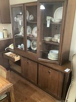 Full view of the buffet and hutch side-by-side showing the wood finish, doors, and drawer