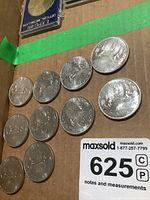 Ten Canadian silver dollar coins from 1978 arranged on a cardboard surface with MaxSold lot tag.
