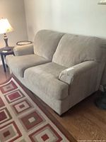 Front view of beige chenille loveseat showing two-seat design and attached cushions