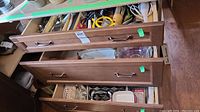 Open drawers showing a variety of kitchen items, cutlery, bakeware, and utensils.