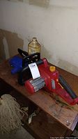 Homelite 14 inch electric chainsaw with bottle of oil and funnel on wooden surface